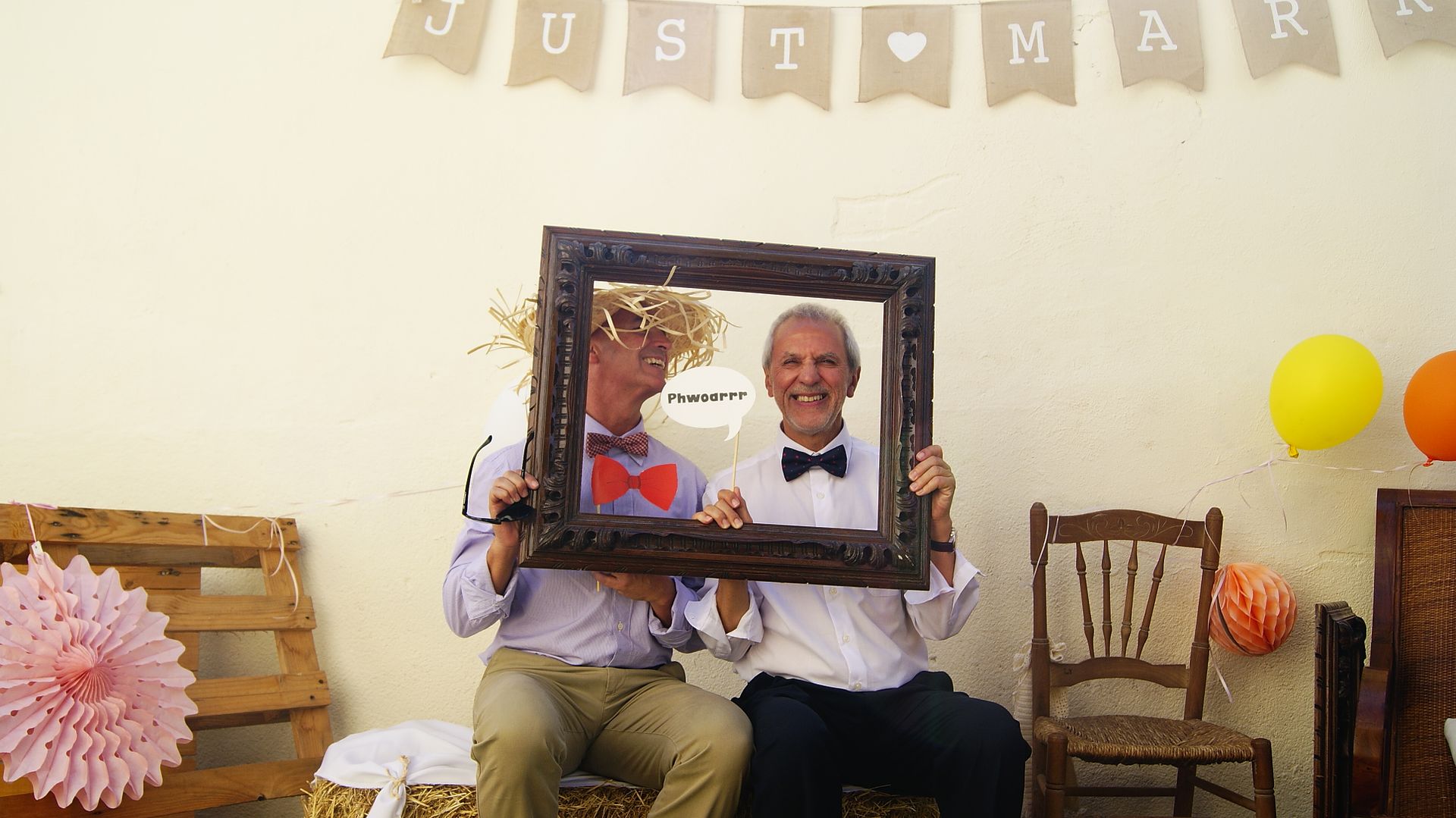 photocall boda posando hombres con marco de cuadro y pajarita
