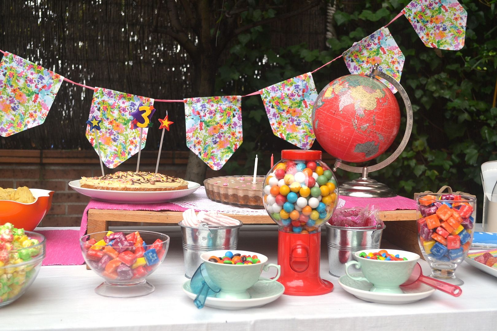 maquina de chicles roja en mesa de dulces de cumpleaños