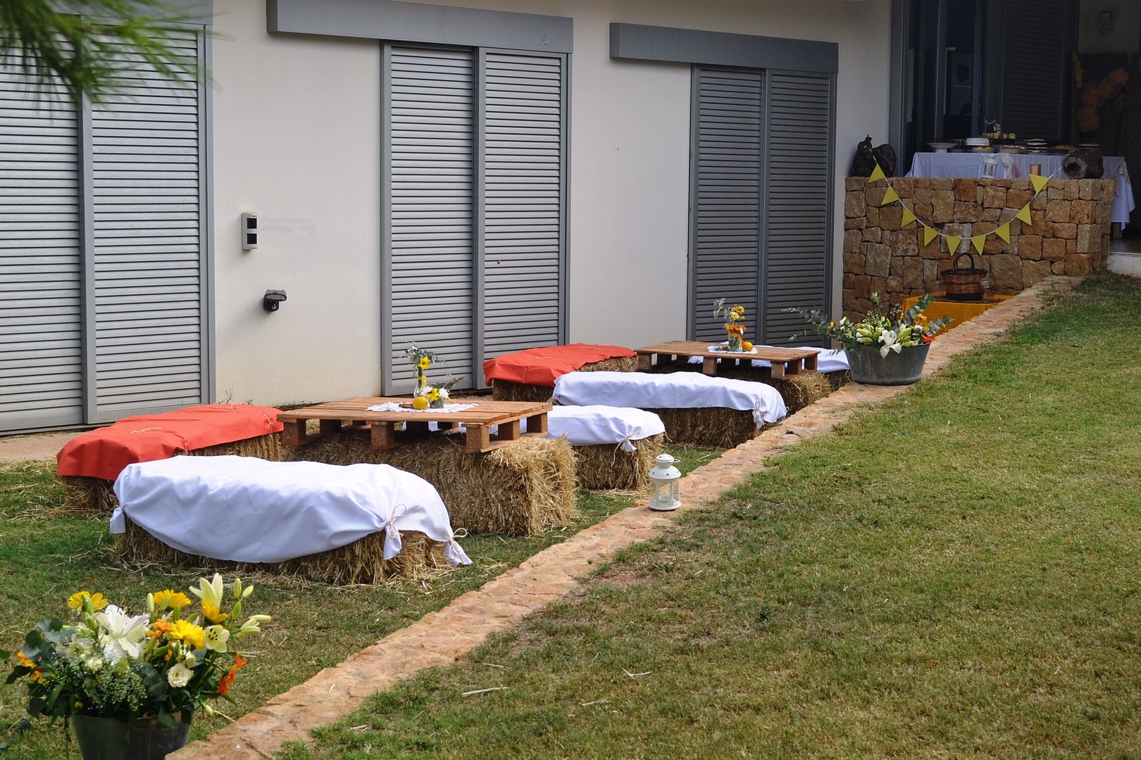  mesas de boda en la terraza con palets y balas de paja